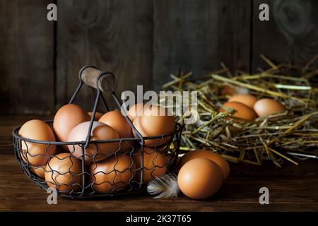 chicken eggs in basket and in nest Stock Photo