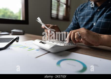 Young asian man calculating expenses household about finance and frustrated on desk at home, male checking bill having stress and worried, debt and Stock Photo