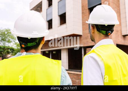 Two engineer architect male workers working at apartment construction site Stock Photo