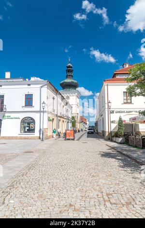 Krosno, Poland - June 12, 2022: Street with Farna bell tower. Stock Photo