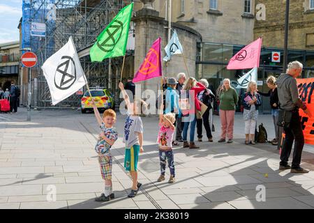 Bath, UK. 25th Sep, 2022. With PM Liz Truss signalling an acceleration of oil and gas extraction in the UK, climate change protesters and children are pictured carrying Extinction Rebellion flags as they take part in a protest march through the centre of Bath. The protest organised by Extinction Rebellion was held in order to highlight how the cost of living crisis and the climate crisis are interlinked. Credit: Lynchpics/Alamy Live News
