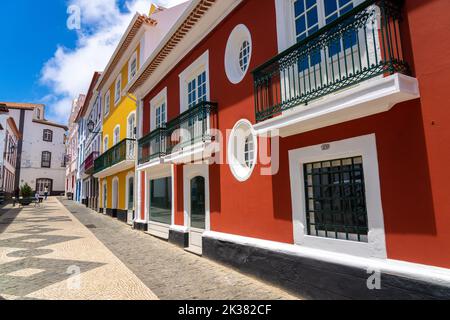 The colorful pastel facades of the neoclassical style buildings along the pedestrian walkway of the Rua da Esperanca ending at the pink Teatro Angrense, a performance art theatre in Angra do Heroismo, Terceira Island, Azores, Portugal. Stock Photo