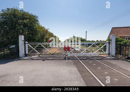 Old style gated Oxmarsh level crossing (Barton on Humber branch) with wooden crossing gates, Stock Photo