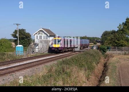 East Midlands railway class 170 turbostar train passing the closed signal box at Roxton sidings, Lincolnshire, UK Stock Photo