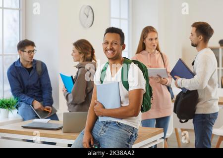 Portrait of smiling ethnic guy student in classroom Stock Photo