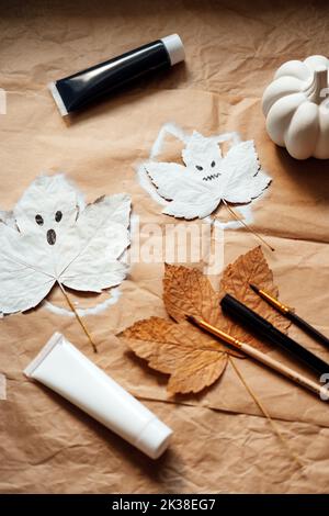 Halloween ghosts from dry maple leaves. Halloween natural DIY decor. Kids art project. Sustainable Eco-Friendly Halloween holiday decoration Stock Photo