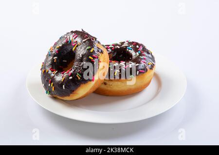 Traditional American donuts with chocolate and pink icing and sprinkles isolated on a white background. Close-up.Donuts. Stock Photo