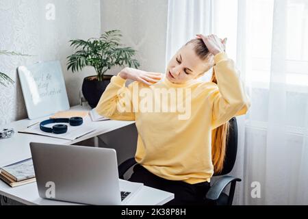 Workout at work. Office Exercises at desk, Desk Friendly Workplace Exercises To Keep Healthy at Office. Young woman office worker at her workplace Stock Photo