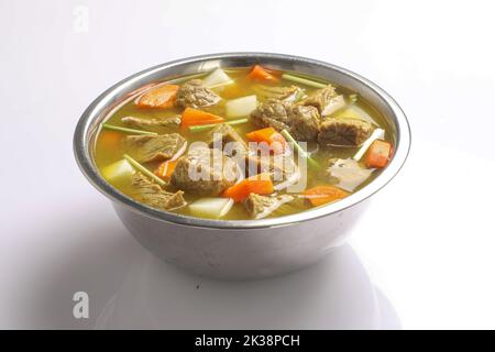 Beef with carrots, onions various fresh vegetables in a pot - colorful fresh clear spring soup. Rural kitchen scenery vegetarian stock Stock Photo