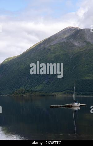 Wonderful landscapes in Norway. Nordland. Beautiful scenery of a sail boat on the Sorfjorden, Kvaloya island. Boat on the fjord and mountain in the ba Stock Photo