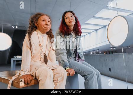 22 July 2022, Neanderthal museum, Germany: Woman visitor looking at Wax child girl of a human ancestor from a stone age Stock Photo