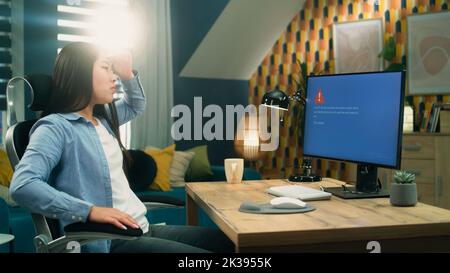 Asian female 3D designer getting angry over computer error while working on 3D modeling and video game development project remotely at home Stock Photo