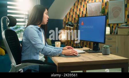 Asian female 3D designer getting angry over computer error while working on 3D modeling and video game development project remotely at home Stock Photo