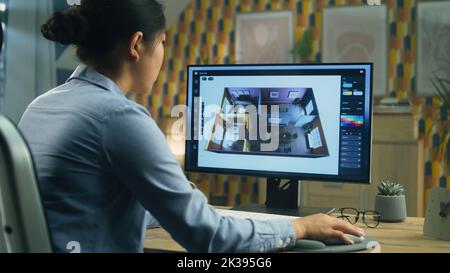 Female designer working remotely from home office and making 3D visualization of house interior in computer program using pc Stock Photo