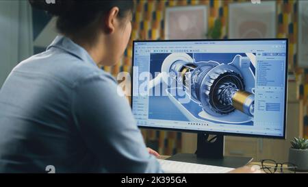 Asian female engineer drawing wind turbine 3D spare part in professional 3D modeling program on pc while working on project at home office Stock Photo