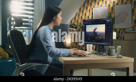 Asian woman editing photo in photoshop for customer on personal computer while sitting at the table at home office and working remotely Stock Photo