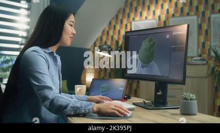 Female asian 3D designer having remote work on 3D modeling and creating 3D visualization of clothes using pc with professional software and tablet computer Stock Photo