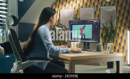 Asian woman editing photo in photoshop for customer on personal computer while sitting at the table at home office and working remotely Stock Photo
