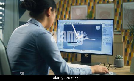 Asian female engineer drawing wind turbine 3D spare part in professional 3D modeling program on pc while working on project at home office Stock Photo