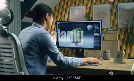Female designer creating 3D visualization of clothes using computer and professional software while working remotely from home Stock Photo