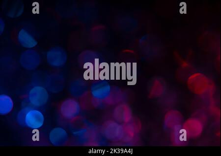 Red and blue bokeh fading to black at top Stock Photo