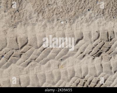 Close up of tire tracks in beach sand Stock Photo