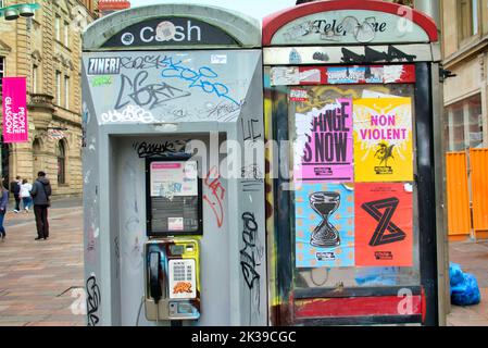 vandalised and graffiti poster strewn call boxes  on. Buchanan street the style mile of Glasgow, Scotland, UK Stock Photo