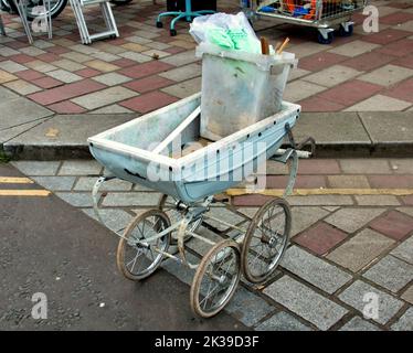 vintage 1960s  dolls pram used to move junk at barras market barrows Glasgow, Scotland, UK Stock Photo