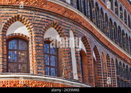 A beautiful building with arches and walls decorated with brown and black bricks in an old town Stock Photo