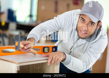 engineer or carpenter man measuring wood with building level Stock Photo