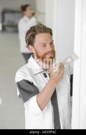 professional painter redecorating a wall using a paintbrush Stock Photo