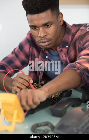 a computer repairman using multimeter Stock Photo