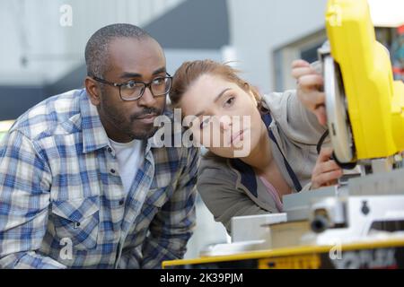 engineer and apprentice examining component in factory Stock Photo