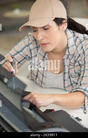 concentrated woman fixing a printer Stock Photo