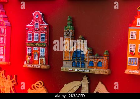 Rows of fridge magnet souvenirs from Gdansk displayed on stillage. Model houses magnets on display in Gdansk Poland travel destination concept in city market square Stock Photo