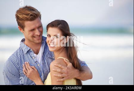 Our love is forever. A young couple embracing happily on the beach. Stock Photo