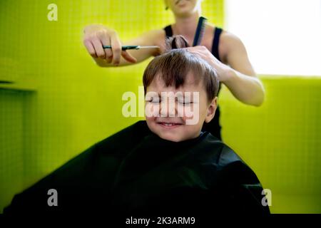 That dreaded back-to-school hair cut...a young boy getting his first haircut. Stock Photo