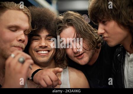 The best way to get in the mood...Cropped portrait of four young male friends. Stock Photo