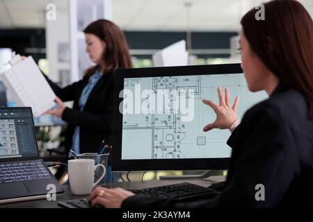 Woman working in room floor planner software, zooming in project draft, designing interior in 2d creator app back view. Cad, blueprints on computer monitor screen, designer plan. Stock Photo