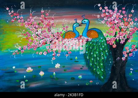 Two peacocks sitting together on flowering pink branch over pond filled with waterlilies Stock Photo