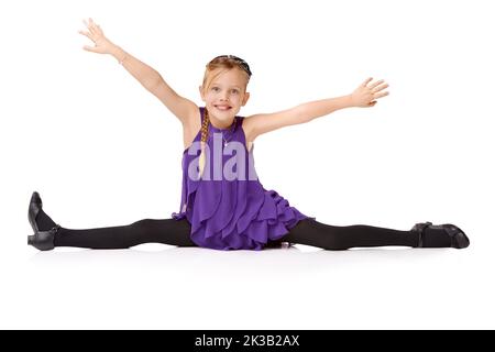 Ta-daa. Full length shot of a young girl doing the splits isolated on white. Stock Photo