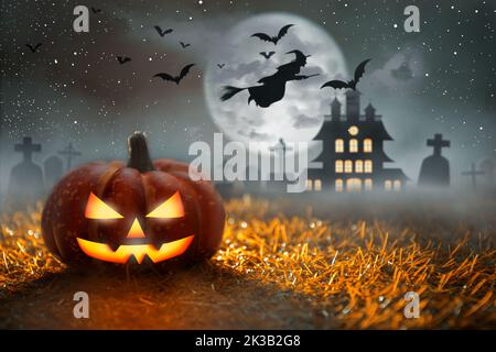 Spooky Halloween Pumpkin in graveyard at moonlight with dead tree and bats. Witch ride broom. Halloween Party and Celebration Concept. Stock Photo