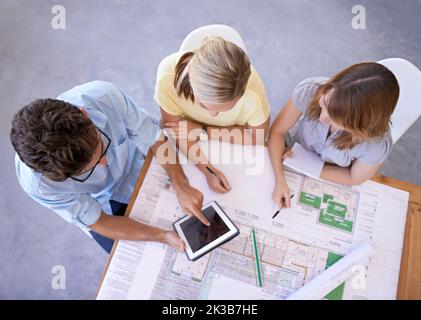 We can find inspiration online. Top view of a group of young architects using a digital tablet to do research together. Stock Photo