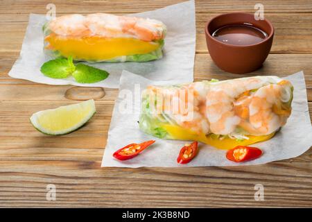 Vietnamese spring rolls with shrimps and sauce on wooden background. Stock Photo
