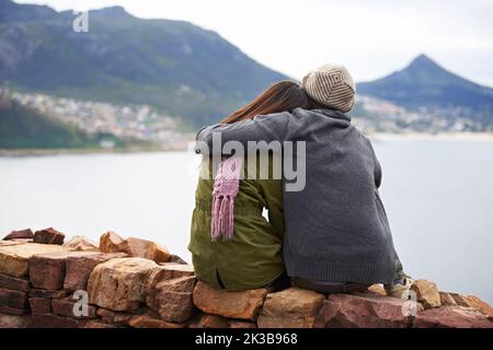 Love at high altitudes. Rearview shot of a young couple enjoying a lovely view. Stock Photo