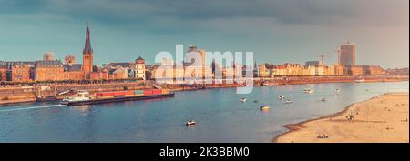 Urban panoramic cityscape view of Dusseldorf old town and transportation waterway of the whole of Germany - the Rhine River, along which large barges Stock Photo