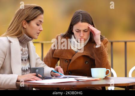 Private teacher teaching to frustrated student in a terrace in winter Stock Photo