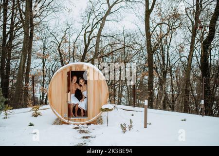 Senior couple enjoying together time in wooden outdoor sauna, relax, spa and healthy lifestlye concept. Stock Photo