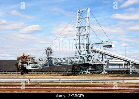 A bucket-wheel stacker-reclaimer and a coal stockpile in a thermal power station on a sunny summer day. Stock Photo