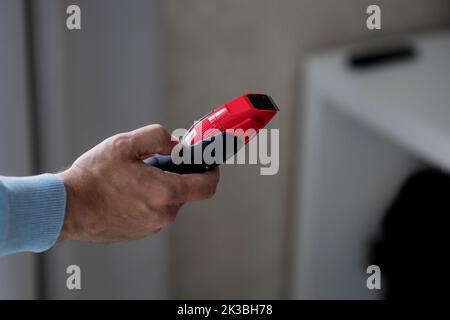 man holds a red electric razor in his hands. self-care and hygiene Stock Photo